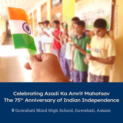 A blurred image of students and teachers holding national flags of India (Tiranga) and standing near one another.